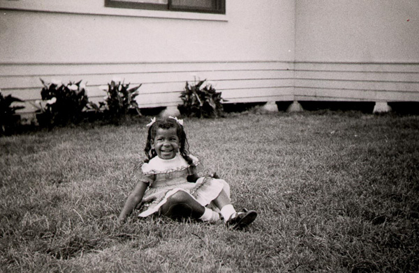 Mom as a toddler sitting on front lawn